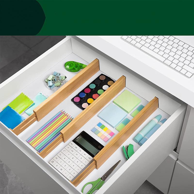 Bamboo drawer dividers organizing a desk drawer with stationery