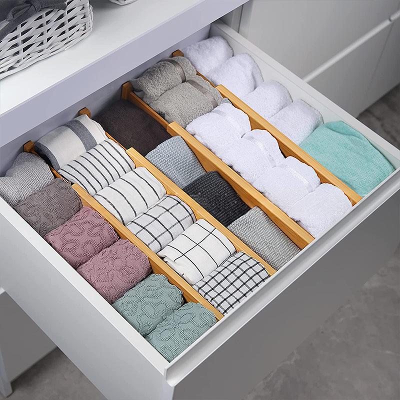 Bamboo drawer dividers organizing folded clothes in a drawer