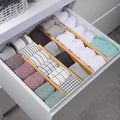 Bamboo drawer dividers organizing folded clothes in a drawer